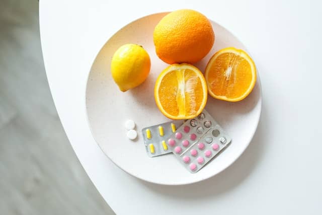 Oranges and lemon on a plate with medications.