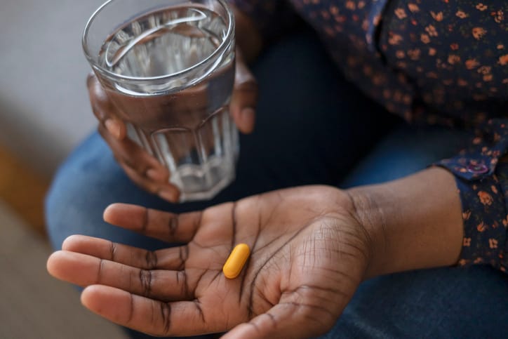 Hand holding pill and water